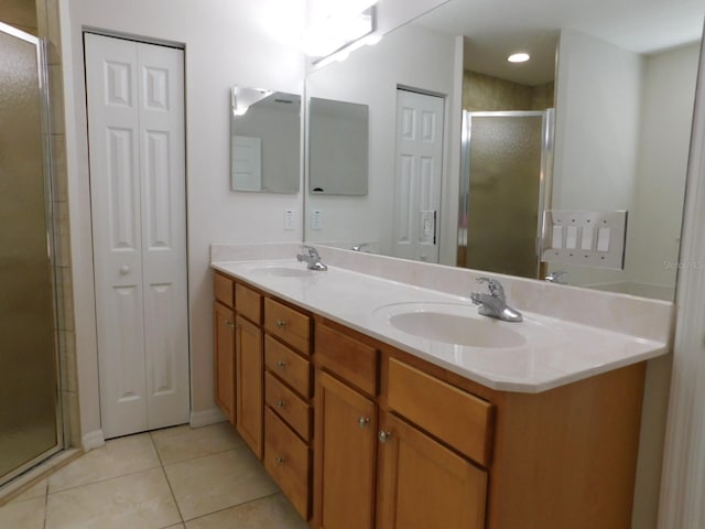 full bath featuring tile patterned floors, a shower stall, double vanity, and a sink