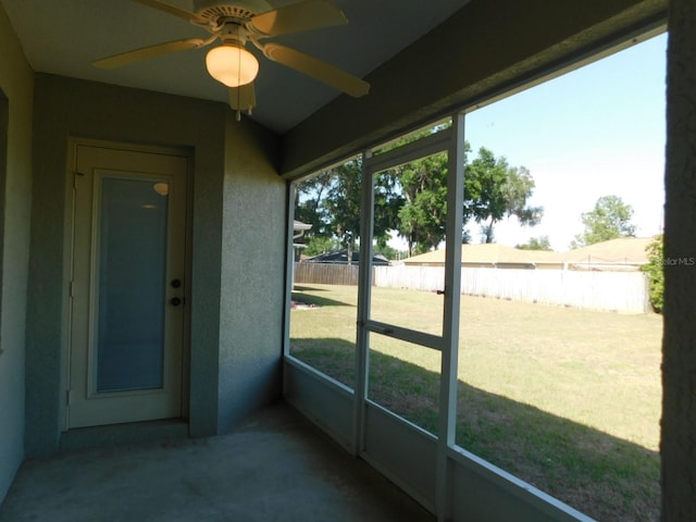 unfurnished sunroom featuring a ceiling fan