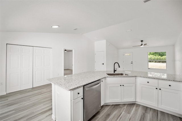 kitchen with stainless steel dishwasher, light wood-style floors, a sink, a ceiling fan, and lofted ceiling