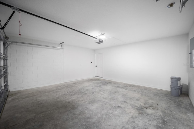 garage with a garage door opener and concrete block wall