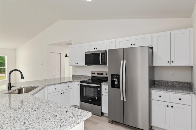 24375 NW Foxglove Ln, Dunnellon, FL 34431 - kitchen featuring appliances with stainless steel finishes, lofted ceiling, a sink, a peninsula, and white cabinetry