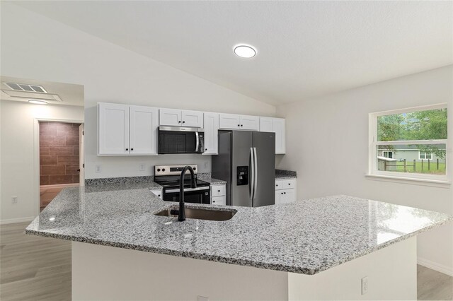 24375 NW Foxglove Ln, Dunnellon, FL 34431 - kitchen featuring stainless steel appliances, a peninsula, a sink, white cabinetry, and light stone countertops