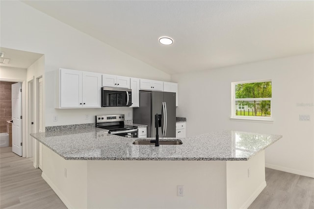 24375 NW Foxglove Ln, Dunnellon, FL 34431 - kitchen featuring stainless steel appliances, light wood-type flooring, white cabinetry, light stone countertops, and vaulted ceiling