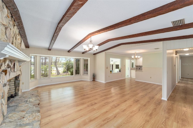1179 SE 170th Ct, Silver Springs, FL 34488 - unfurnished living room featuring a chandelier, a stone fireplace, and light wood-type flooring