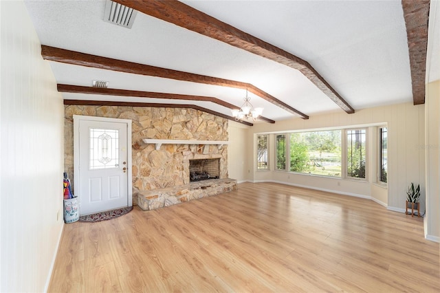 1179 SE 170th Ct, Silver Springs, FL 34488 - unfurnished living room with a chandelier, wood finished floors, and a stone fireplace