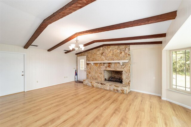 1179 SE 170th Ct, Silver Springs, FL 34488 - unfurnished living room with wood finished floors, a chandelier, and a stone fireplace