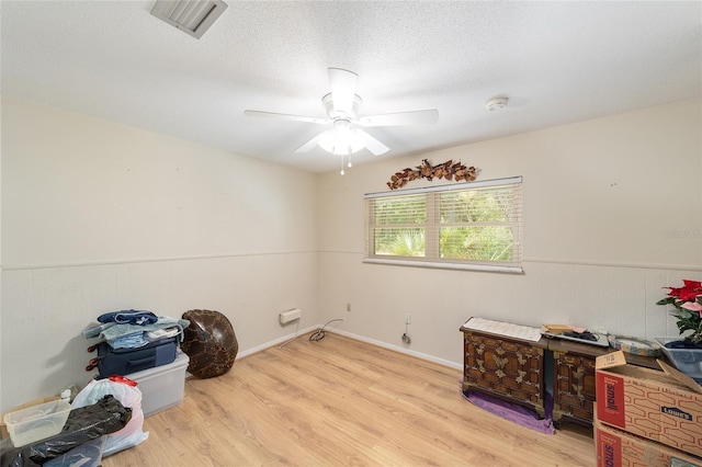 1179 SE 170th Ct, Silver Springs, FL 34488 - miscellaneous room featuring wood finished floors, a ceiling fan, a textured ceiling, wainscoting, and wooden walls