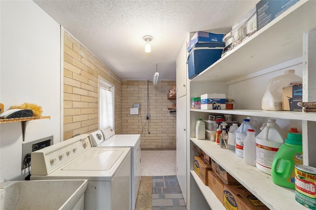 1179 SE 170th Ct, Silver Springs, FL 34488 - laundry area featuring brick wall, washing machine and clothes dryer, and a textured ceiling