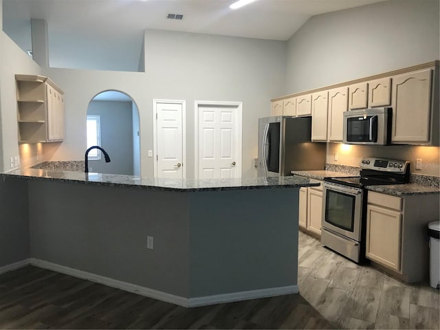 11411 SW 138th Ln, Dunnellon, FL 34432 - kitchen with stainless steel appliances, open shelves, a peninsula, and light wood-style floors
