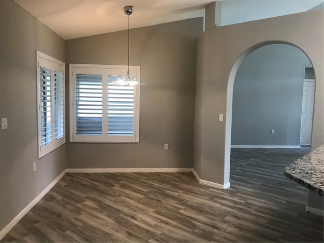 11411 SW 138th Ln, Dunnellon, FL 34432 - unfurnished dining area featuring baseboards, arched walkways, dark wood-style flooring, and vaulted ceiling