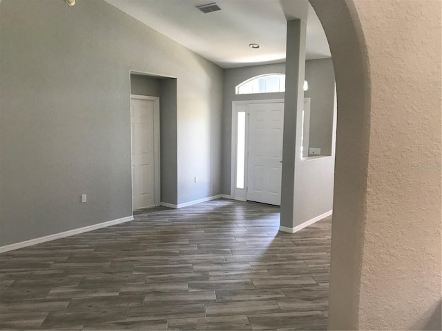 11411 SW 138th Ln, Dunnellon, FL 34432 - foyer entrance with visible vents, a textured wall, baseboards, arched walkways, and dark wood finished floors