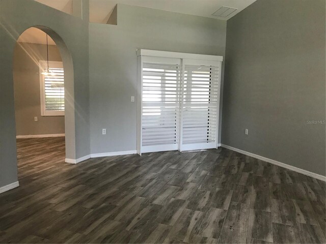 11411 SW 138th Ln, Dunnellon, FL 34432 - empty room featuring baseboards, arched walkways, and dark wood-style floors