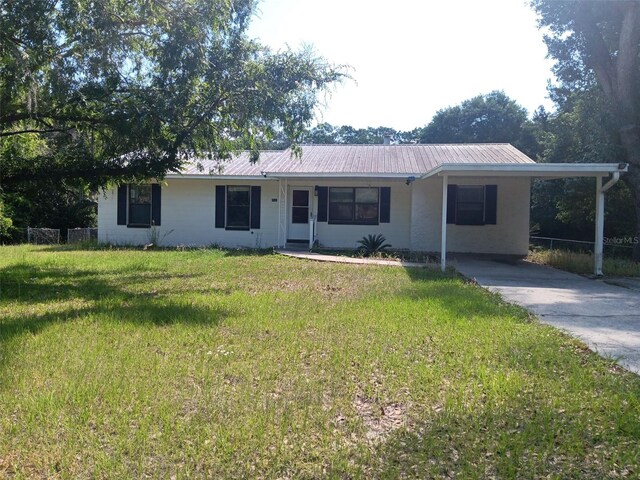 2531 NE 167th Ave, Williston, FL 32696 - ranch-style home with driveway, metal roof, a front yard, and a carport