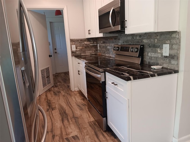 2531 NE 167th Ave, Williston, FL 32696 - kitchen featuring dark countertops, appliances with stainless steel finishes, white cabinetry, and visible vents