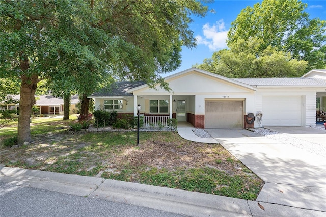 ranch-style home with brick siding, a garage, driveway, and a porch