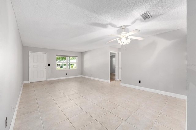 unfurnished room featuring light tile patterned floors, a ceiling fan, a textured ceiling, and visible vents