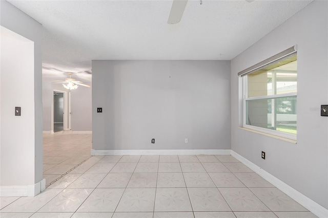 spare room featuring baseboards, a ceiling fan, a textured ceiling, and light tile patterned flooring