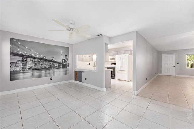 spare room with visible vents, baseboards, ceiling fan, and light tile patterned floors