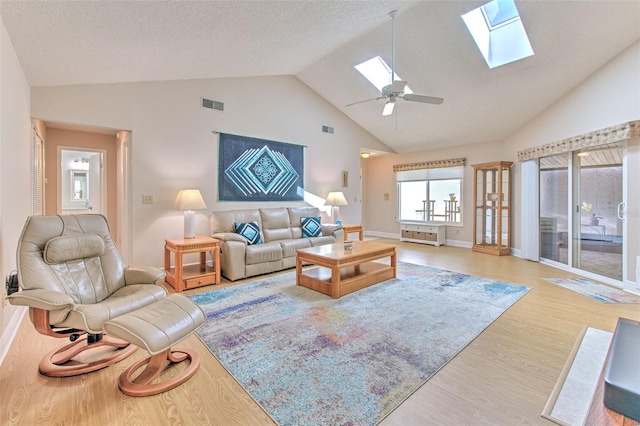 7102 Silvermill Dr, Tampa, FL 33635 - living room featuring ceiling fan, high vaulted ceiling, visible vents, light wood-style flooring, and a skylight