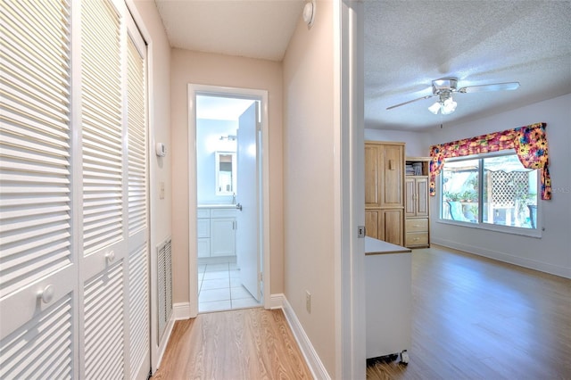 7102 Silvermill Dr, Tampa, FL 33635 - hall with a textured ceiling, wood finished floors, and baseboards