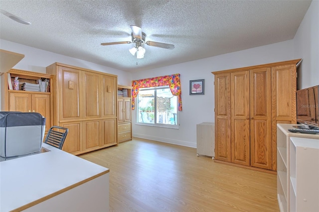 7102 Silvermill Dr, Tampa, FL 33635 - office area with a textured ceiling, ceiling fan, baseboards, and light wood-type flooring