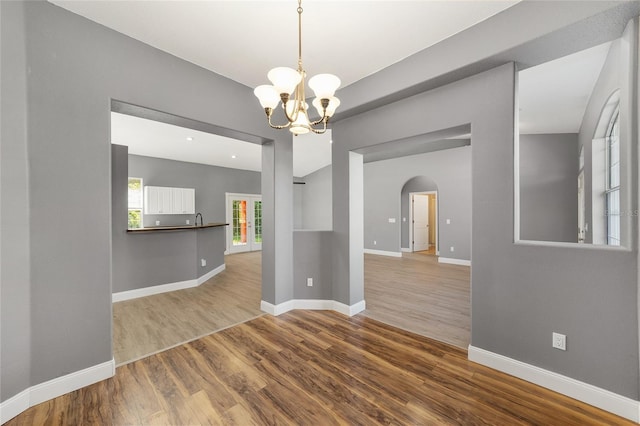 15087 SW 43rd Ct, Ocala, FL 34473 - unfurnished room featuring arched walkways, wood finished floors, a chandelier, and baseboards