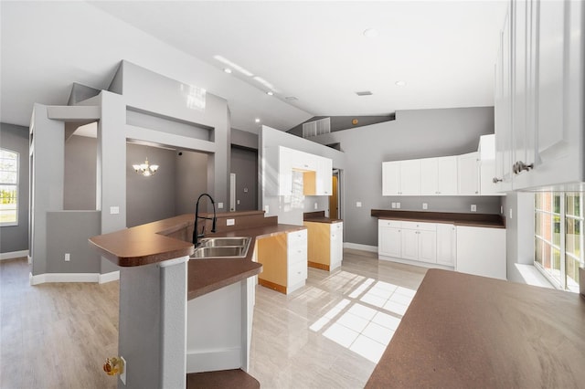 15087 SW 43rd Ct, Ocala, FL 34473 - kitchen with a sink, lofted ceiling, plenty of natural light, dark countertops, and baseboards