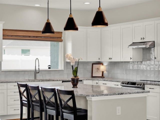 4806 NW 8th Ter, Ocala, FL 34475 - kitchen with white cabinets, a sink, under cabinet range hood, stainless steel electric stove, and a kitchen island