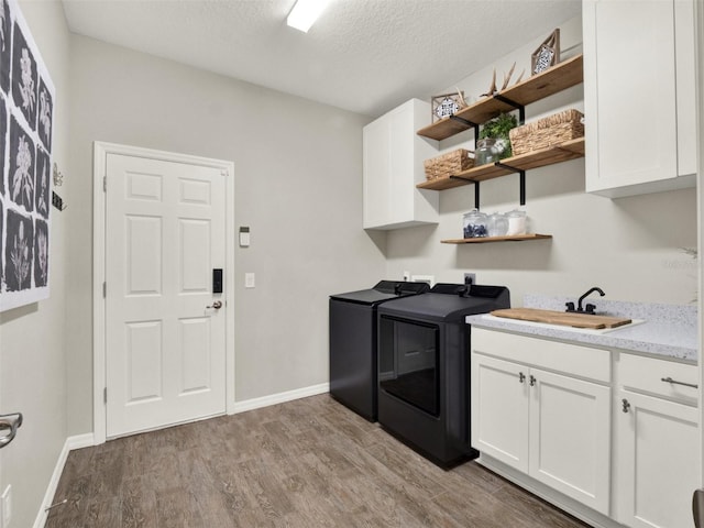 4806 NW 8th Ter, Ocala, FL 34475 - laundry area featuring wood finished floors, baseboards, washer and clothes dryer, a textured ceiling, and a sink