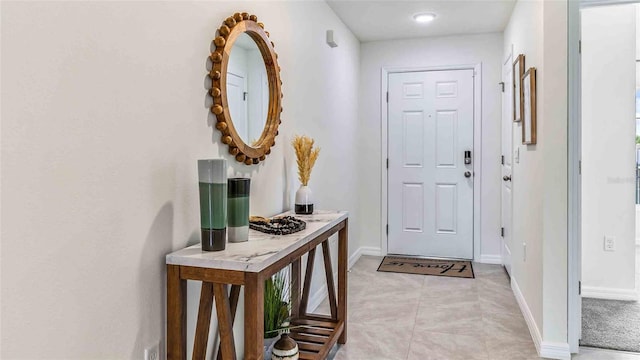 interior space with light tile patterned flooring and baseboards