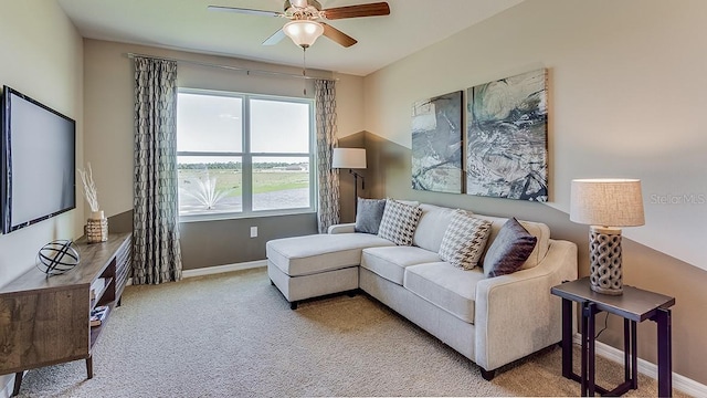 carpeted living room featuring a ceiling fan and baseboards