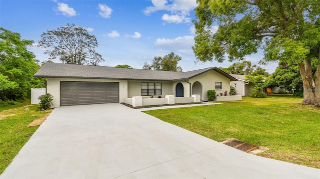 single story home featuring stucco siding, an attached garage, driveway, and a front yard