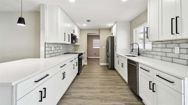 kitchen featuring a sink, light countertops, stainless steel appliances, baseboards, and recessed lighting