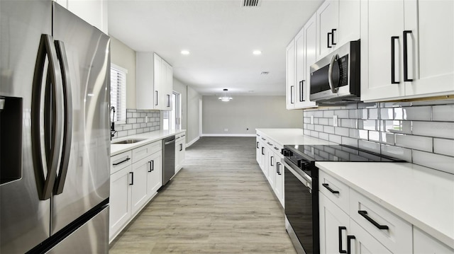 kitchen featuring a sink, light countertops, stainless steel appliances, baseboards, and decorative backsplash