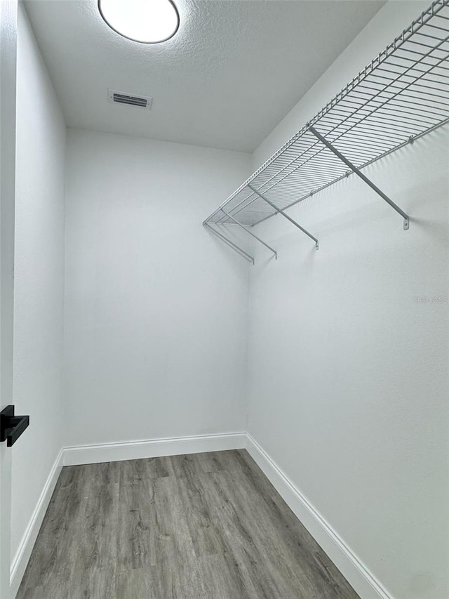spacious closet featuring visible vents and wood finished floors