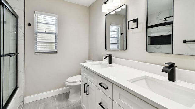 bathroom with a sink, toilet, and a healthy amount of sunlight