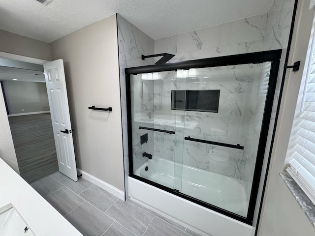 full bathroom with baseboards, a textured ceiling, and enclosed tub / shower combo