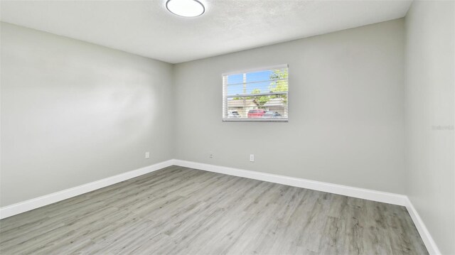 empty room with baseboards and wood finished floors