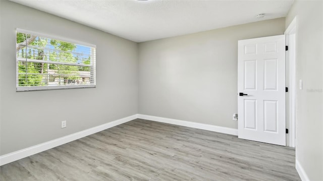 empty room featuring baseboards and wood finished floors