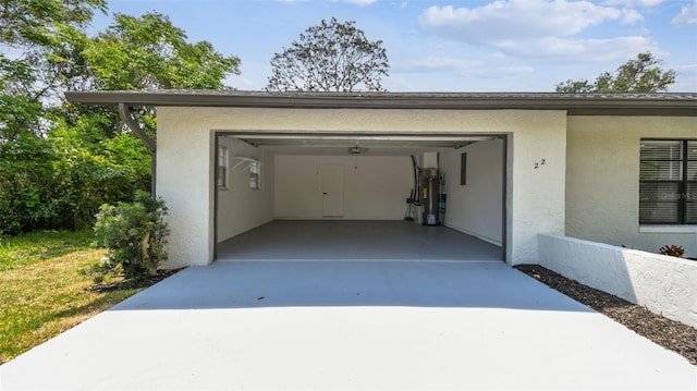 garage featuring water heater and concrete driveway