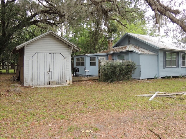 219 SE 3rd Ave, Williston, FL 32696 - rear view of property with an outbuilding, a lawn, and a storage unit