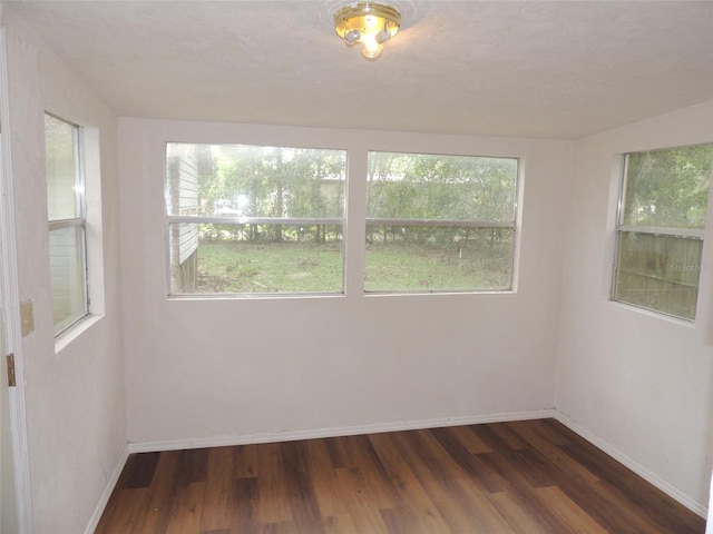 219 SE 3rd Ave, Williston, FL 32696 - spare room featuring baseboards and dark wood-type flooring