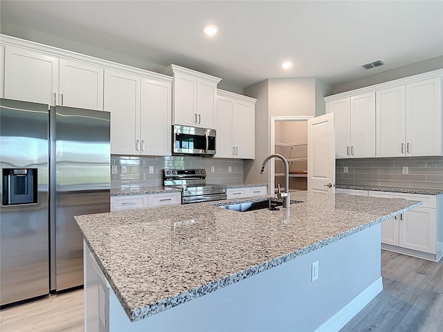 2423 Sadnet Ln, North Port, FL 34286 - kitchen featuring a sink, backsplash, stainless steel appliances, and light wood-type flooring
