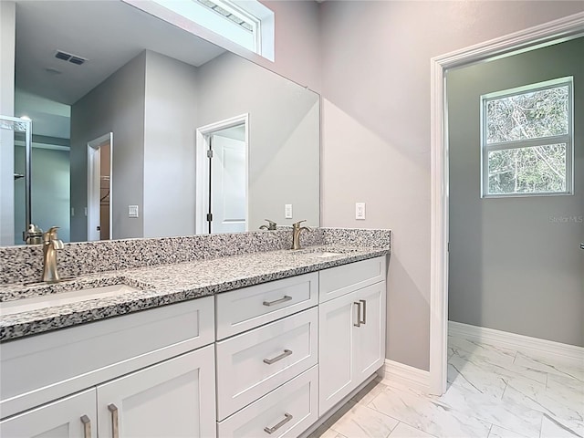 2423 Sadnet Ln, North Port, FL 34286 - bathroom featuring baseboards, marble finish floor, double vanity, and a sink