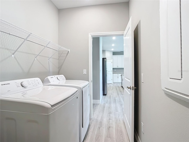 2423 Sadnet Ln, North Port, FL 34286 - laundry room with light wood finished floors, independent washer and dryer, a heating unit, laundry area, and baseboards