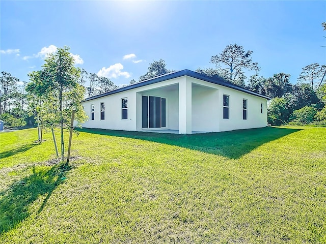 2423 Sadnet Ln, North Port, FL 34286 - view of side of home with stucco siding and a yard