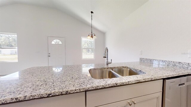 1610 SW 152nd Ct, Ocala, FL 34481 - kitchen with light stone countertops, stainless steel dishwasher, decorative light fixtures, vaulted ceiling, and a sink