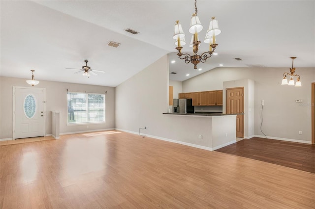 13425 SW 106th Pl, Dunnellon, FL 34432 - unfurnished living room featuring light wood-type flooring, ceiling fan with notable chandelier, lofted ceiling, and visible vents