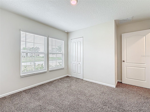 19 Roxland Ln, Palm Coast, FL 32164 - unfurnished bedroom featuring carpet flooring, a textured ceiling, baseboards, and a closet