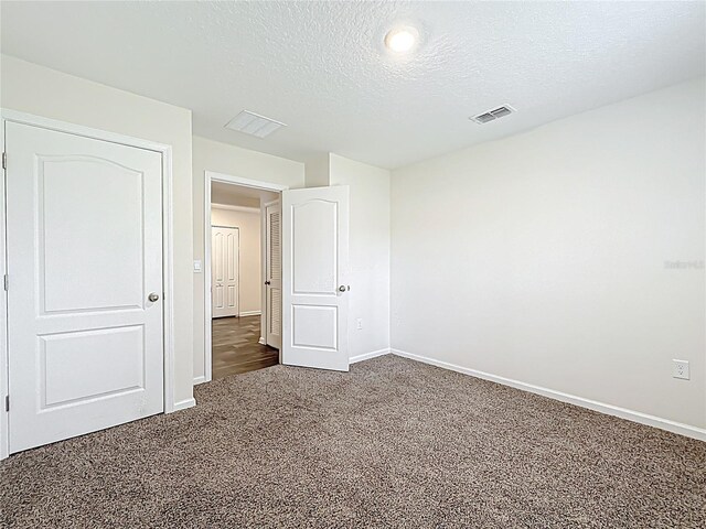 19 Roxland Ln, Palm Coast, FL 32164 - unfurnished bedroom with carpet flooring, a textured ceiling, baseboards, and visible vents